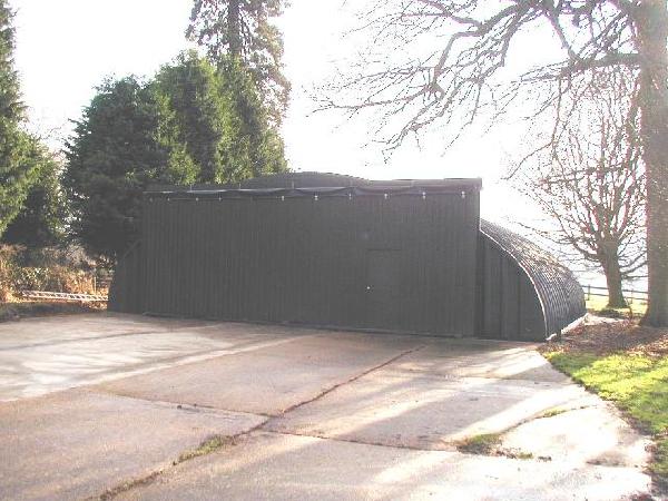Painted arch building with sliding doors with aircraft storage