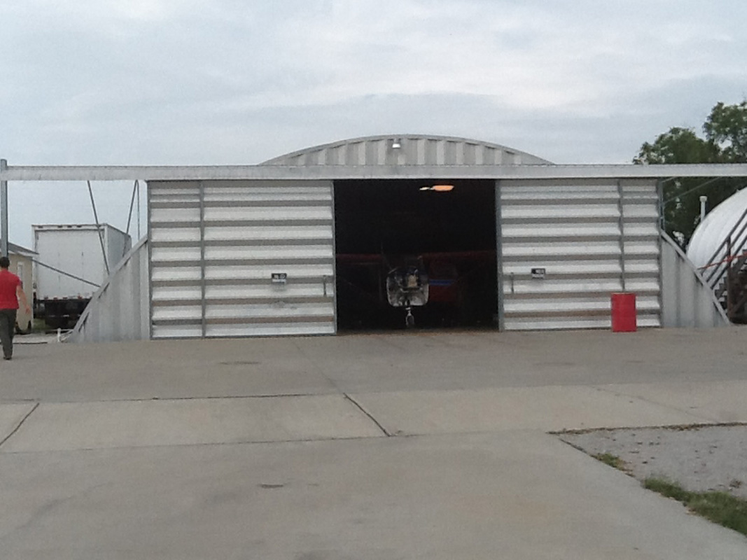 Arch building airplane hangar with sliding doors