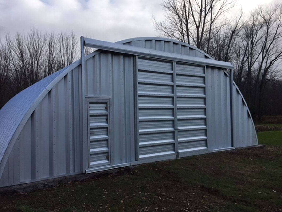 Arch building with sliding doors and man door
