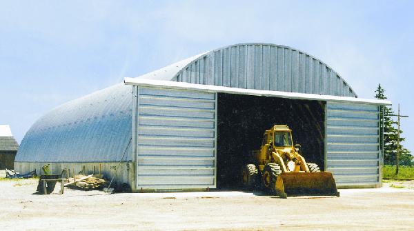 Arch building with sliding doors and front end loader